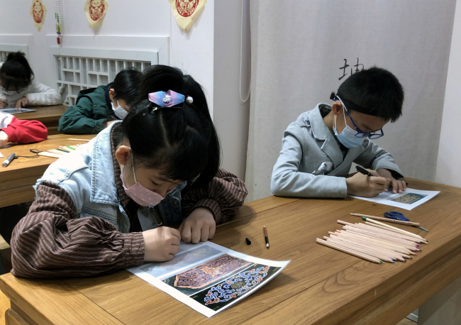 Les enfants essaient de peindre un petit dessin à l’ancien style de peinture aux couleurs