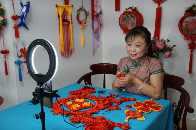 Η Λιου Μιν ζωντανεύει την τέχνη της δημιουργίας κινεζικών κόμπων από το σπίτι της στην Τιεντζίν. （SONG RUI / XINHUA）