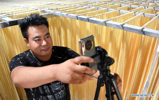 Ο παραγωγός ζυμαρικών Τζανγκ Γιουσίν πωλεί ζυμαρικά ‘νιουτζίν’ ( που σημαίνει ‘τένοντας βοδιού’) στο Διαδίκτυο στην κομητεία Ντανφένγκ, Σανγκλουό, στην επαρχία Σαανσί της βορειοδυτικής Κίνας, στις 20 Ιουλίου 2020.