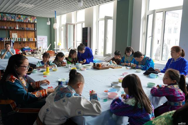 Παιδάκια μαθαίνουν να φτιάχνουν στολίδια ηλίανθου στο εργαστήριο της Ουράν. (Φωτογραφία / cctv.com)<br>