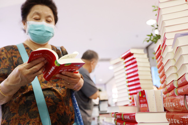 Ένας πελάτης ρίχνει μια ματιά στην τελευταία έκδοση του Λεξικού Xinhua σε ένα βιβλιοπωλείο στο Πεκίνο στις 11 Αυγούστου 2020. [Φωτογραφία: CFP]