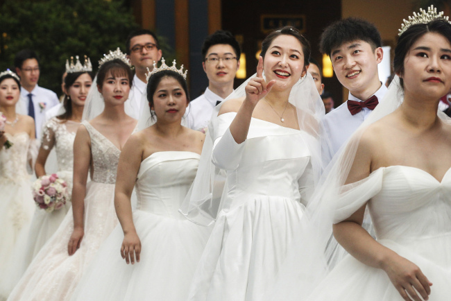 Η Τσούι (τρίτη από δεξιά) με τον Γιάο (δεύτερος από δεξιά)στον ομαδικό γάμο που έγινε στο Μποάο της επαρχίας Χαϊνάν στις 6 Ιουνίου 2020.<br>