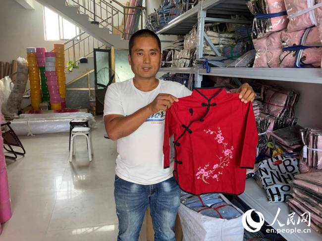 Ξεπερνώντας τη φτώχεια, ο Σουν Σιλιάνγκ διαθέτει πλέον το δικό του κατάστημα σχεδιασμού και κατάστημα κοστουμιών στο διαδίκτυο. (People's Daily Online / Kou Jie)