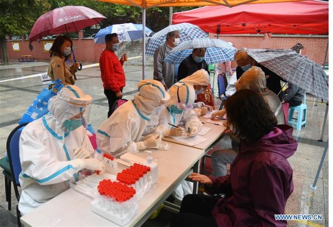 Οι άνθρωποι περιμένουν να κάνουν COVID-19 τεστ σε μια πλατεία στην πόλη Τσινγκντάο, στην επαρχία Σαντόνγκ της ανατολικής Κίνας, στις 14 Οκτωβρίου 2020. (φωτογραφία / Xinhua)