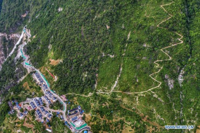 Η φωτογραφία που τραβήχτηκε στις 29 Ιουνίου 2020 δείχνει νεόχτιστα δρομάκια χωριού και έναν οικισμό μετεγκατάστασης με μονοπάτια που οδηγούν στο αρχικό χωριό στο χωριό Αμπουλουόχα της κομητείας Μπουτουό στον αυτόνομο νομό Λιανγκσάν Γι, στην επαρχία Σιτσουάν της νοτιοδυτικής Κίνας. (φωτογραφία/Xinhua)