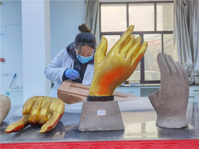 Συντηρητής εργάζεται σε ένα πέτρινο κομμάτι στο κέντρο συντήρησης της Ακαδημίας, τον Δεκέμβριο. [Φωτογραφία από τον Wang Kaihao / China Daily]