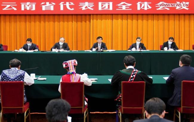 Ο Γουάνγκ Χουνίνγκ, μέλος της Μόνιμης Επιτροπής του Πολιτικού Γραφείου της Κεντρικής Επιτροπής του Κομμουνιστικού Κόμματος της Κίνας και μέλος της Γραμματείας της Κεντρικής Επιτροπής του ΚΚΚ, συμμετέχει σε μια ομαδική συζήτηση με αντιπροσώπους από την επαρχία Γιουνάν κατά τη διάρκεια της τέταρτης συνόδου του 13ου Εθνικού Λαϊκού Συνεδρίου (NPC) στο Πεκίνο, πρωτεύουσα της Κίνας , 7 Μαρτίου 2021. (φωτογραφία: Xinhua)