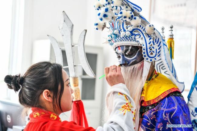 Μαθητές μακιγιάρουν ο ένας τον άλλο, πριν από την πρόβα στο 3ο Γυμνάσιο της κομητείας Λονγκλί, στον Αυτόνομο Νομό Τσιενάν Μπουγί και Μιάο που βρισκεται στην νοτιοδυτική Κίνα στις 23 Μαρτίου 2021. <br>