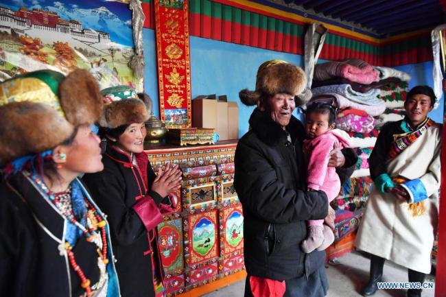 Ο Μπασάνγκ (κέντρο) μιλά με την οικογένειά του στο σπίτι του στο χωριό Τάγιε του Σιγκάζε, στην Αυτόνομη Περιοχή του Θιβέτ της νοτιοδυτικής Κίνας, στις 21 Μαρτίου 2021. <br>