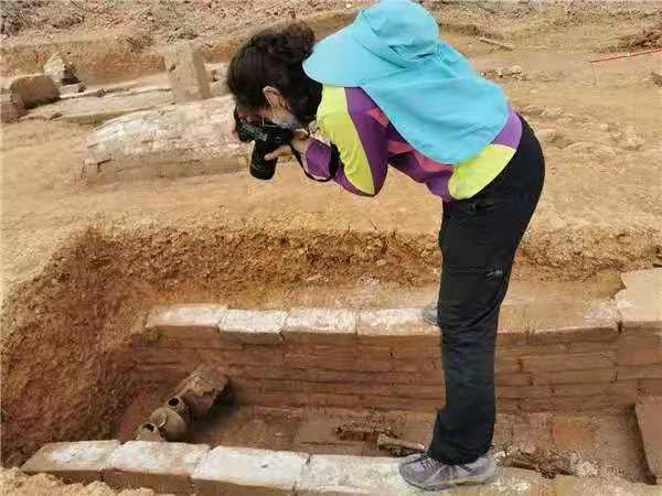 Εικόνα της Γιαν Νι ενώ παίρνει φωτογραφίες από μόλις ανακαλυφθέντα αντικείμενα στο χώρο ανασκαφής στο Χετσουάν.