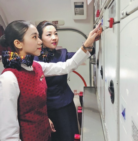 Η Χουάνγκ Πεϊχουά (αριστερά) εργάζεται κάνοντας την πρακτική της υπό την καθοδήγηση ενός εκπαιδευτή σε πτήση της Air China.