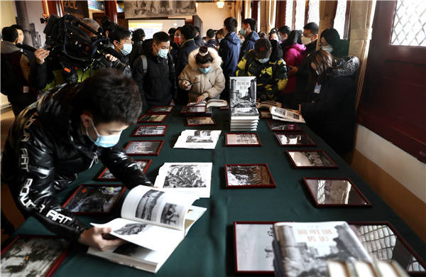 Επισκέπτες διαβάζουν βιβλία και έγγραφα που υπάρχουν στην έκθεση. [Φωτογραφία: Zou Hong / China Daily]