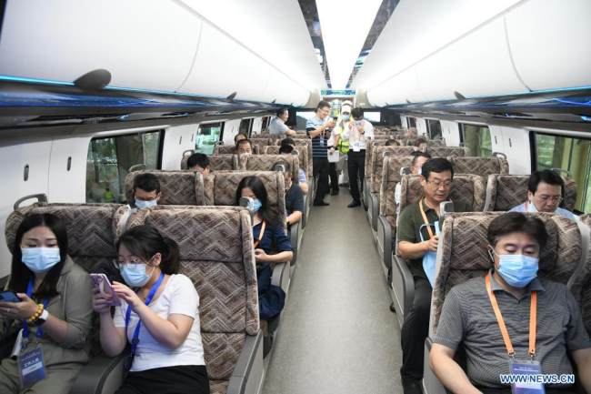 Επισκέπτες δοκιμάζουν μέσα σε ένα βαγόνι του νέου maglev τρένου υψηλής ταχύτητας της Κίνας στην πόλη Τσινγκντάο, στην επαρχία Σαντόνγκ της ανατολικής Κίνας, στις 20 Ιουλίου 2021.