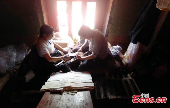 Εργαζόμενοι τυπώνουν γραφές στο Τυπογραφείο Ντέργκε Σούτρα, στην κομητεία Ντέργκε, της αυτόνομης περιφέρειας των θιβετιανών Γκάρζε, στην επαρχία Σιτσουάν στις 20 Ιουλίου 2021.