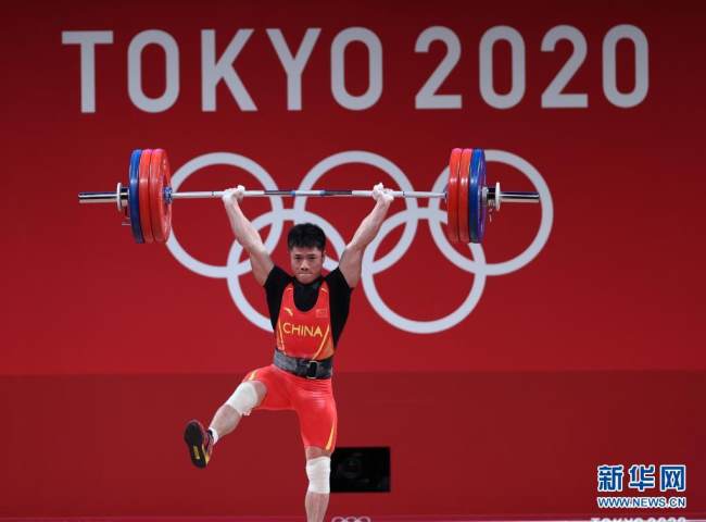 Ο Κινέζος αθλητής Λι Φαμπίν κατά τον αγώνα της άρσης βαρών ανδρών κατηγορίας 61 κιλών στους Ολυμπιακούς Αγώνες του Τόκιο στις 24 Ιουλίου 2021. (φωτογραφία / Xinhua)