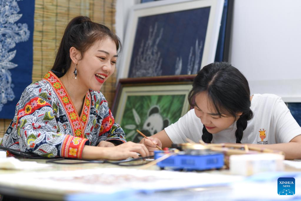 Η Τζουάν – Τζουάν  δείχνει στην αδερφή της πως να ζωγραφίζει στο στούντιό της στο Ανσούν της επαρχίας Γκουιτζόου της νοτιοδυτικής Κίνας, 18 Αυγούστου 2022.