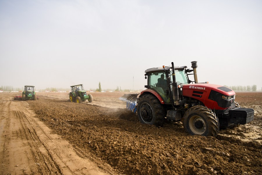 Αυτή η φωτογραφία που τραβήχτηκε στις 2 Απριλίου 2023 δείχνει γεωργικές μηχανές να εργάζονται σε ένα χωράφι με βαμβάκι στην κομητεία Μάρκιτ στην Αυτόνομη Περιοχή Σιντζιάνγκ Ουιγούρ της βορειοδυτικής Κίνας, 30 Μαρτίου 2023. (Xinhua/Ding Lei)