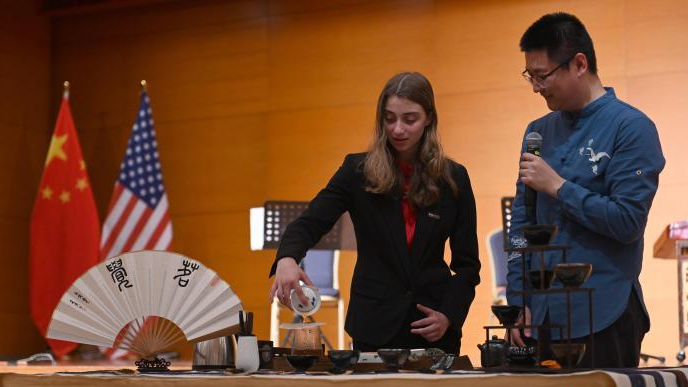 Eine Besucherin bereitet Tee mit traditionellem Teegeschirr bei einer Kulturveranstaltung der chinesischen Botschaft in den USA zu.