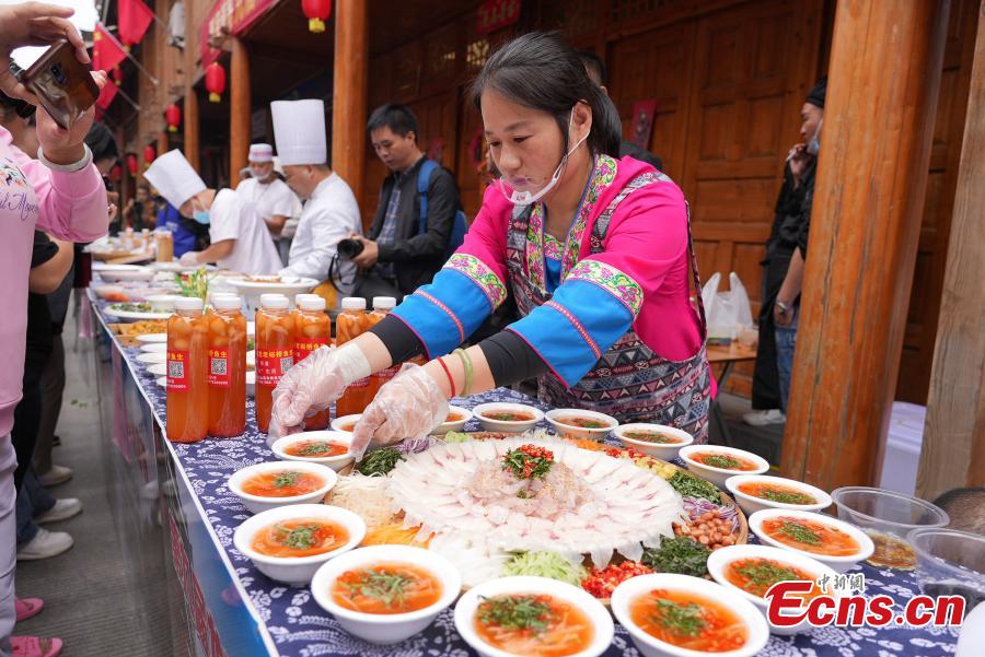 Οι χωρικοί συμμετέχουν σε έναν διαγωνισμό σερβιρίσματος ωμού ψαριού κατά τη διάρκεια ενός λαϊκού φεστιβάλ για τον εορτασμό της συγκομιδής στην κομητεία Λονγκσένγκ του Γκουιλίν, της αυτόνομης περιοχής Γκουανγκσί Τζουάνγκ της Νότιας Κίνας, 10 Οκτωβρίου 2023.. (Φωτογραφία: China News Service/Wei Jiyang)