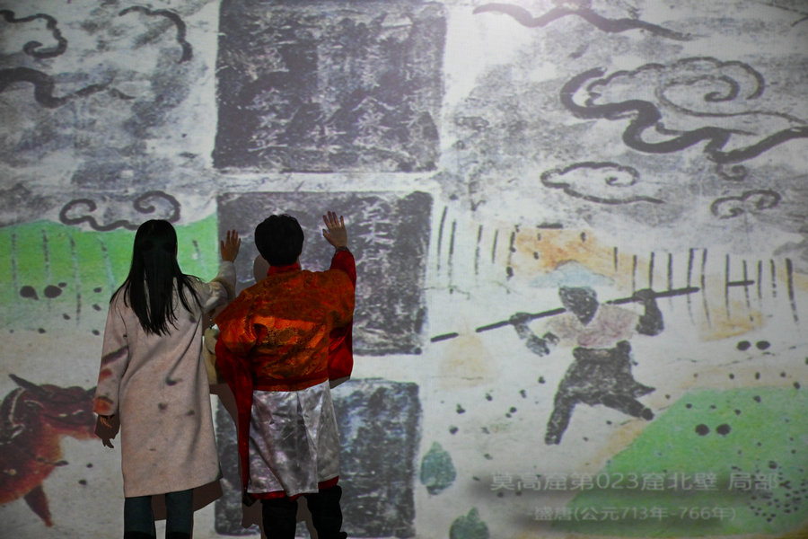 Επισκέπτες στην έκθεση με θέμα τον πολιτισμό Ντουνχουάνγκ στο Μουσείο Ψηφιακής Τέχνης στο Τιεντζίν της βόρειας Κίνας, στις 28 Νοεμβρίου 2023. [Φωτογραφία/Xinhua]