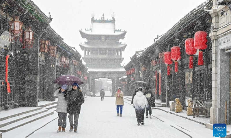 Τουρίστες επισκέπτονται την αρχαία πόλη Πινγκγιάο τώρα το χειμώνα που είναι χιονισμένη, στην επαρχία Σανσί της βόρειας Κίνας, 14 Δεκεμβρίου 2023. (Φωτογραφία: Xinhua)  