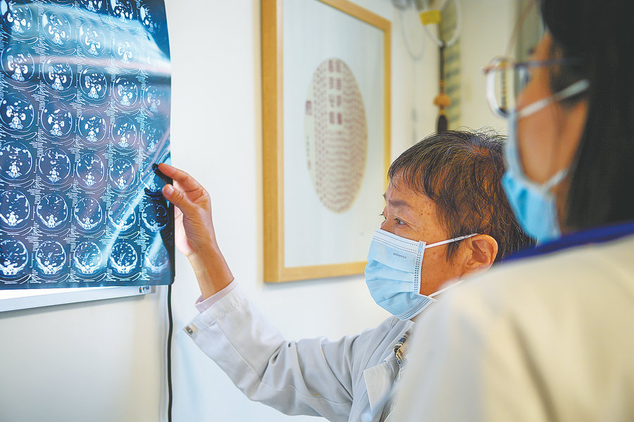 Μελετώντας μια ακτινογραφία ενός ασθενούς, η Τσιν συζητά επιλογές με την ομάδα της. [Φωτογραφία από Pan Songgang/Sun Ren/For China Daily]