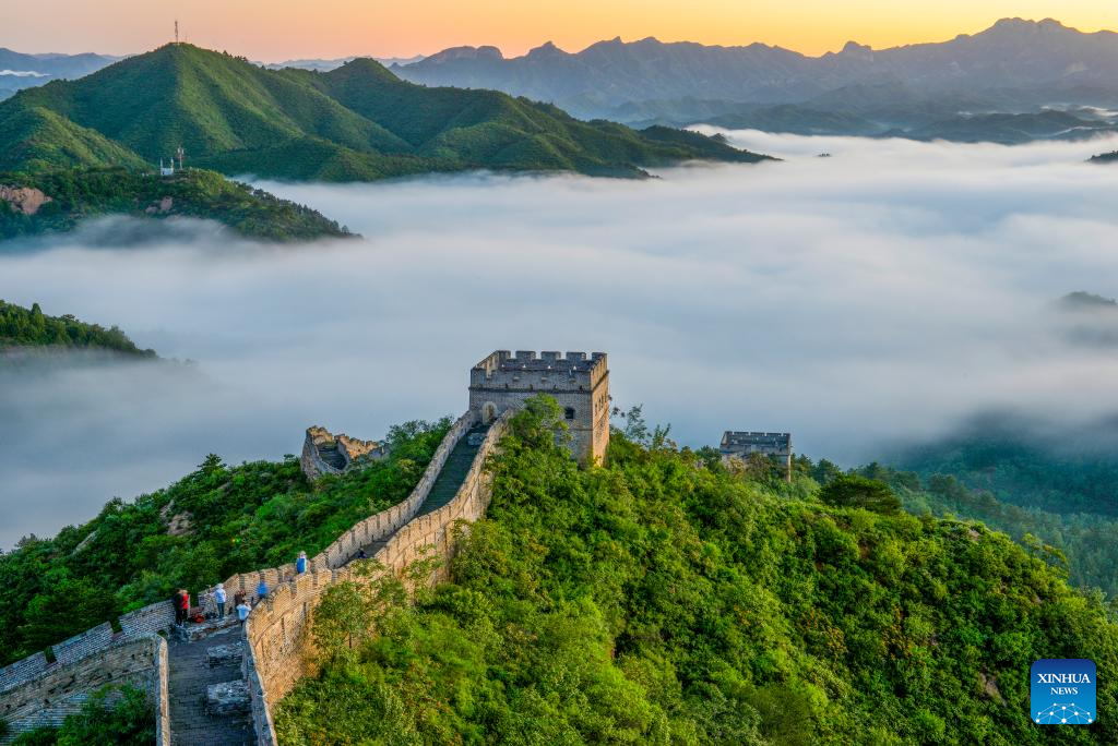 Οι τουρίστες απολαμβάνουν το θερινό τοπίο στο τμήμα Τζινσανλίνγκ του Σινικού Τείχους στην κομητεία Λουανπίνγκ, στην επαρχία Χεμπέι της βόρειας Κίνας, 22 Αυγούστου 2023.   (Φωτογραφία Zhou Wanping/Xinhua)