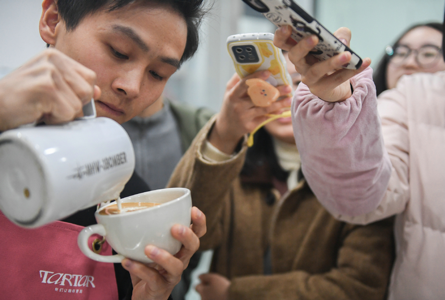 Ο εκπαιδευτής Ντάι Χουί (πρώτος αριστερά) παρουσιάζει την τέχνη του καφέ latte κατά τη διάρκεια μιας βραδινής σχολικής τάξης στην περιοχή Τσιαοκόου του Γουχάν, στην επαρχία Χουμπέι της Κεντρικής Κίνας, 4 Ιανουαρίου 2024. [Φωτογραφία/Xinhua]