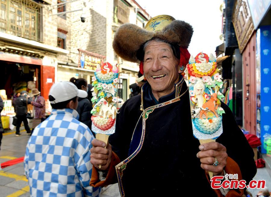 Τεχνίτης παρουσιάζει γλυπτά με βούτυρο για τον εορτασμό του Λοσάρ, ή αλλιώς το Θιβετιανό Νέο Έτος, στη Λάσα, στην αυτόνομη περιοχή Σιζάνγκ της νοτιοδυτικής Κίνας, στις 30 Ιανουαρίου, 2024. (Φωτογραφία: China News Service/Li Lin)