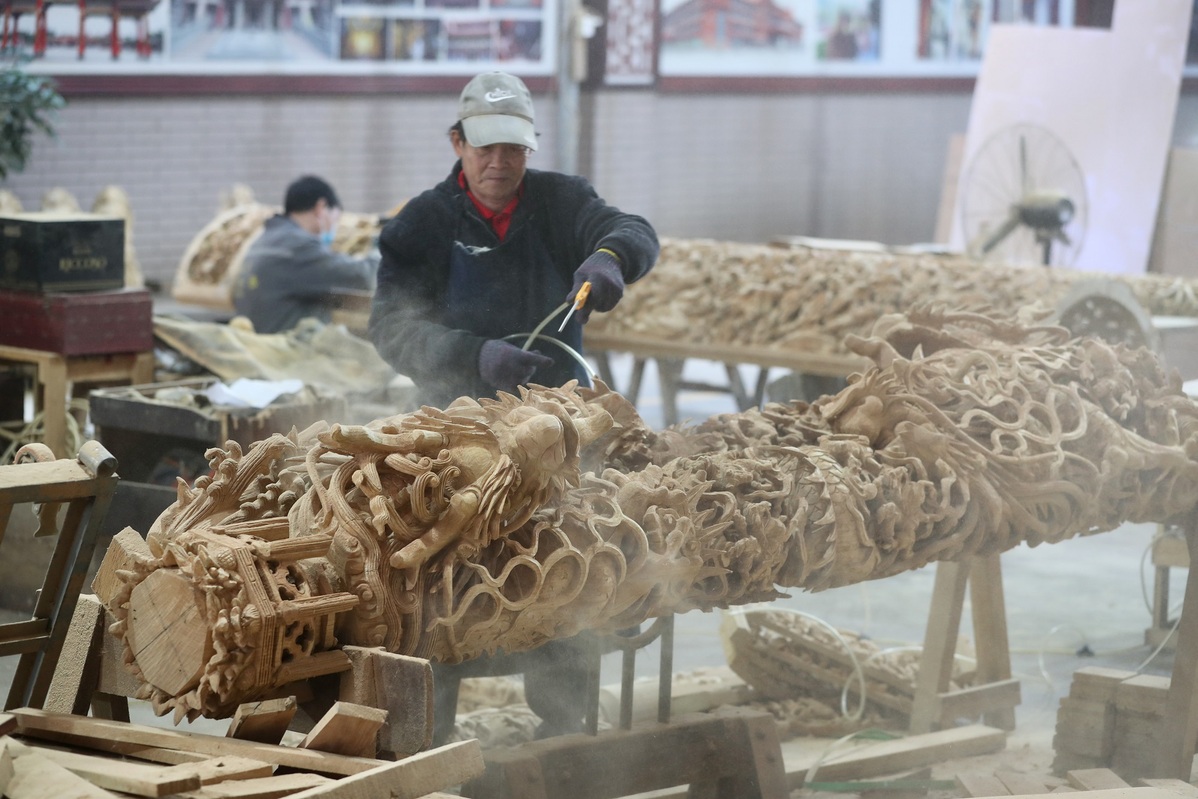 Εργάτες καθαρίζουν τη σκόνη από τους πυλώνες δράκου μέσα στο εργαστήριο Jinjiang Yida Ancient Architecture Engineering Co Ltd στο χωριό Πανσάν του Τζιντζιάνγκ της επαρχίας Φουτζιέν, 27 Ιανουαρίου 2024. [Φωτογραφία από τον Liu Lianfen/ Για chinadaily.com.cn]