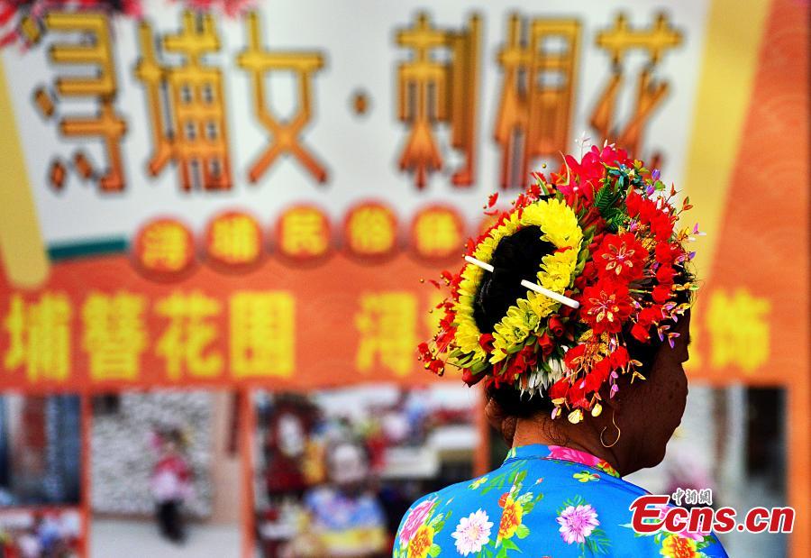 Μια γυναίκα φοράει ένα ανθοφόρο καπελάκι στο Σουνπού του Τσουεντζόου, στην επαρχία Φουτζιέν της ανατολικής Κίνας, 21 Φεβρουαρίου 2024. (Φωτογραφία: China News Service/Zhang Bin)