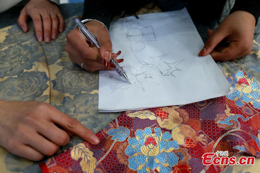 Σχεδιάστρια ζωγραφίζει μοτίβα λουλουδιών για φούστες μαμιεντσούν σε ένα εργοστάσιο ρούχων στην κομητεία Τσαοσιέν,  στην επαρχία Σανντόνγκ της ανατολικής Κίνας, 4 Μαρτίου 2024. (Φωτογραφία: China News Service/Liang Ben)