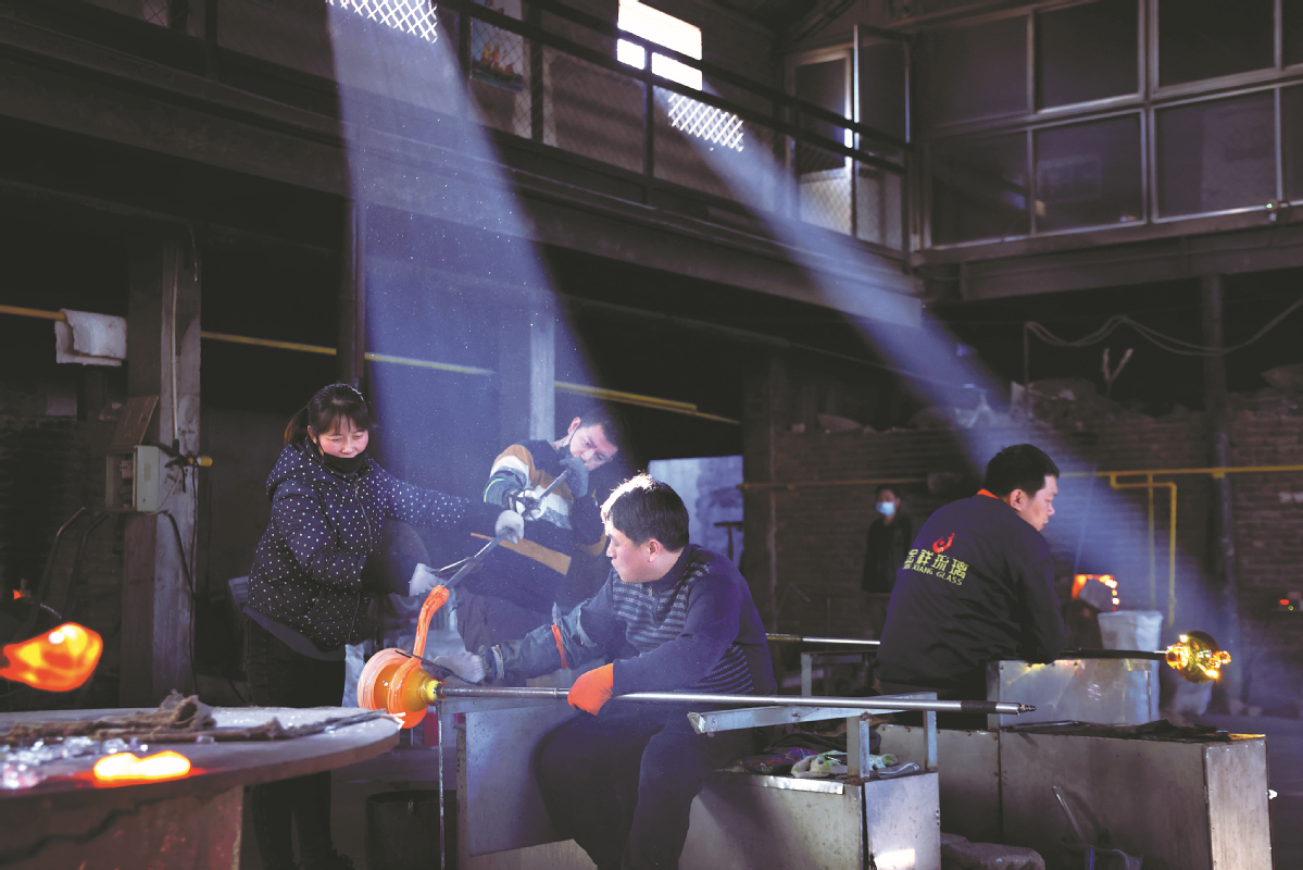 Τεχνίτες στο Jinxiang Glass Studio δημιουργούν έργα τέχνης από γυαλί, σε φωτογραφία από τις 23 Ιανουαρίου. [Φωτογραφία Wang Jing/China Daily]