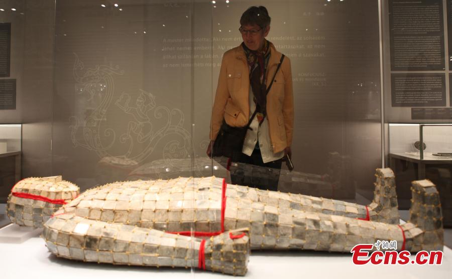 Επισκέπτρια παρατηρεί νεκρικό ρουχισμό από νεφρίτη ραμμένο με χρυσό σύρμα που χρονολογείται από τη Δυτική Δυναστεία Χαν (202 π.Χ. - 9 μ.Χ.) σε μια έκθεση στην Ουγγαρία, 7 Μαΐου 2024. (Φωτογραφία: China News Service/De Yongjian)
