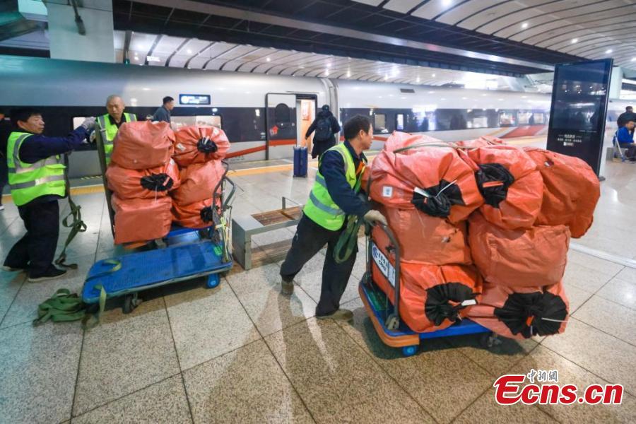 Το προσωπικό της China Railway φορτώνει σάκους με δέματα, τα περισσότερα από τα οποία προέρχονται από τις ηλεκτρονικές αγορές της Ημέρας των Singles ή Ανύπαντρων όπως ονομάζεται η 11η Νοεμβρίου, σε ένα τρένο υψηλής ταχύτητας στο Νότιο σιδηροδρομικό σταθμό του Πεκίνου, στις 11 Νοεμβρίου 2024. (Φωτογραφία: China News Service/Jia Tianyong)